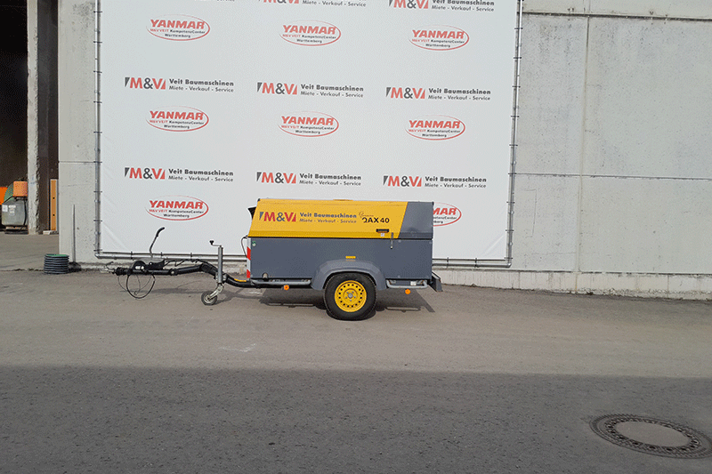 Seitenansicht des Atlas Copco Stromerzeugers QAX 40 auf Anhänger mit kompakter Bauweise für den flexiblen Einsatz als mobiler Baustromerzeuger.